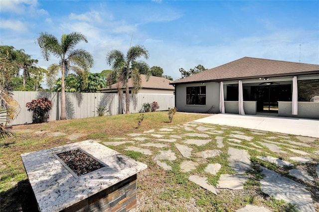 view of yard featuring a fire pit and a patio