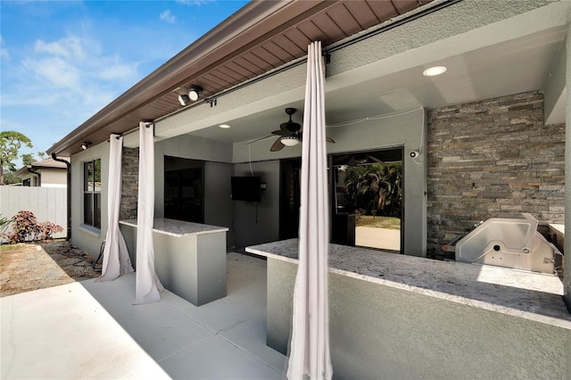 view of patio with ceiling fan and area for grilling