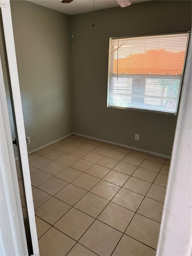 spare room featuring ceiling fan and light tile patterned floors