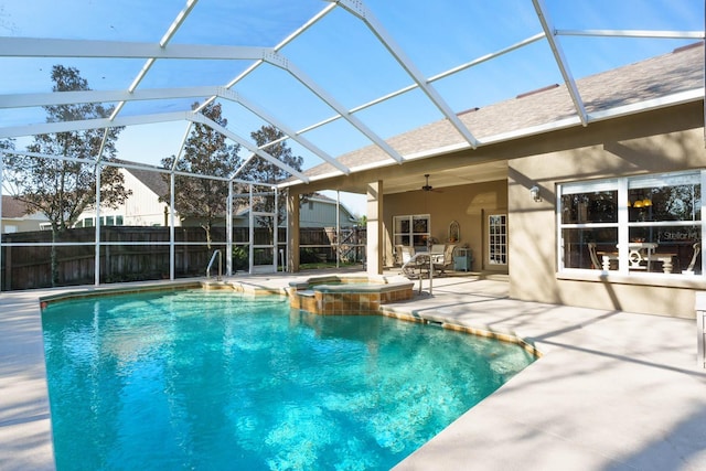 view of pool featuring ceiling fan, a patio area, glass enclosure, and an in ground hot tub