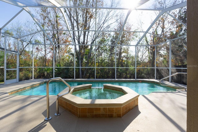 view of pool with a lanai, a patio, and an in ground hot tub