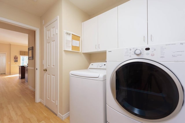 laundry area featuring light wood-type flooring, cabinets, and independent washer and dryer