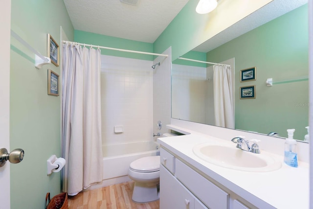 full bathroom with a textured ceiling, shower / tub combo, toilet, wood-type flooring, and vanity