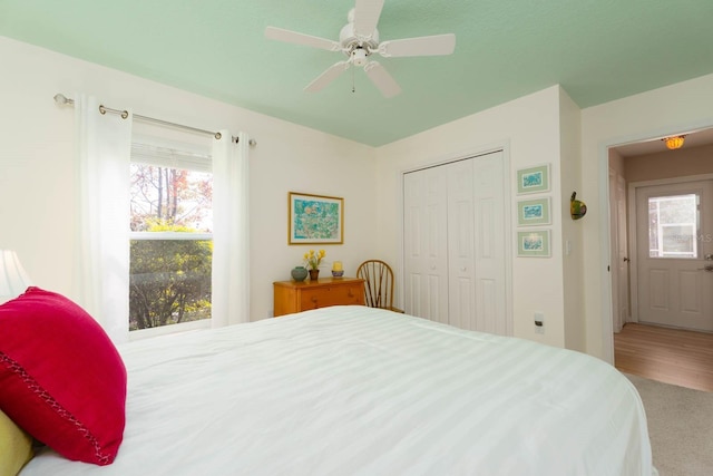 carpeted bedroom featuring ceiling fan and a closet