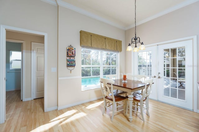 dining room with french doors, crown molding, and light hardwood / wood-style floors