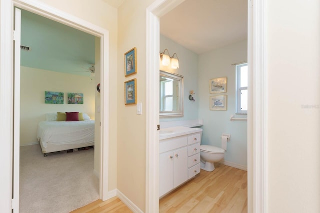 bathroom featuring toilet, vanity, ceiling fan, and hardwood / wood-style flooring