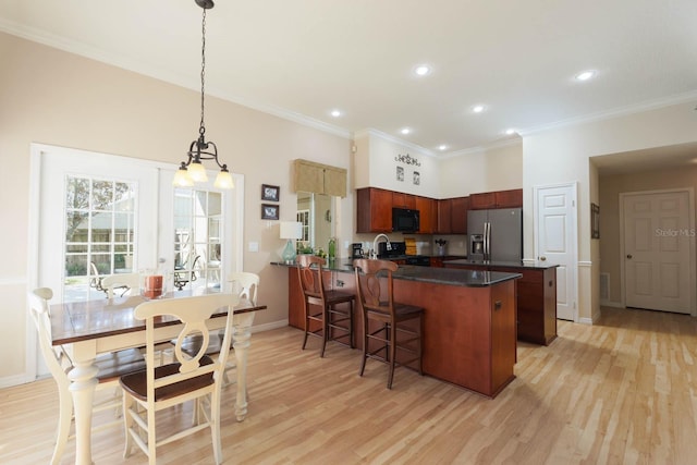 kitchen featuring a kitchen bar, light wood-type flooring, kitchen peninsula, hanging light fixtures, and stainless steel refrigerator with ice dispenser