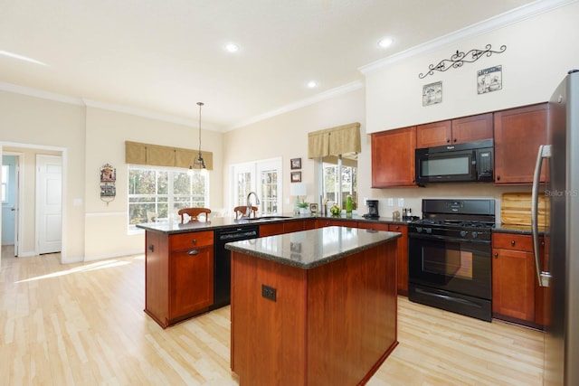 kitchen with kitchen peninsula, a center island, black appliances, ornamental molding, and sink