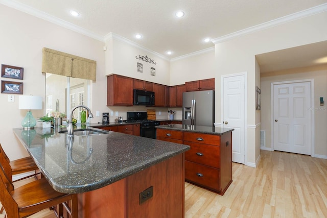 kitchen with black appliances, crown molding, kitchen peninsula, a kitchen island, and sink