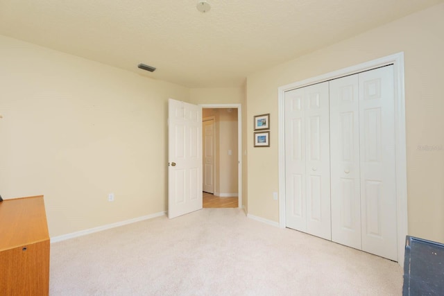 unfurnished bedroom featuring a closet and light carpet