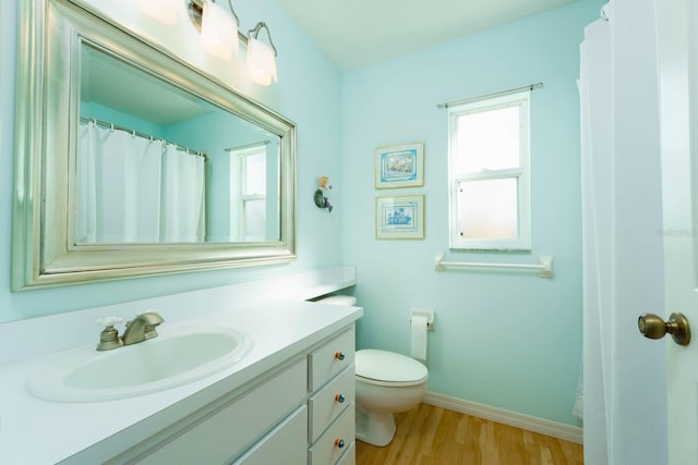 bathroom featuring toilet, wood-type flooring, and vanity