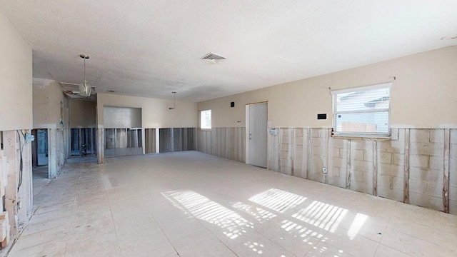 empty room featuring a textured ceiling and plenty of natural light