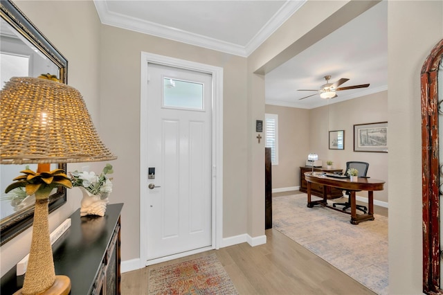 foyer entrance featuring ceiling fan, crown molding, and light hardwood / wood-style flooring