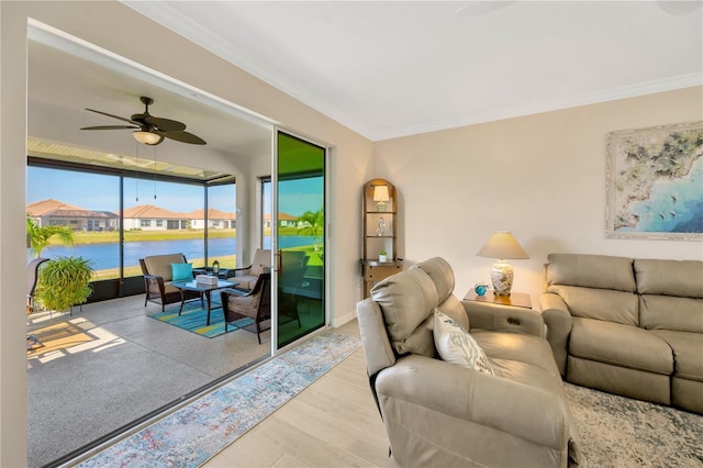 living room with ceiling fan, crown molding, and a water view