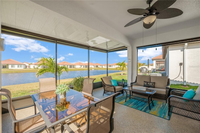 sunroom with a water view and ceiling fan