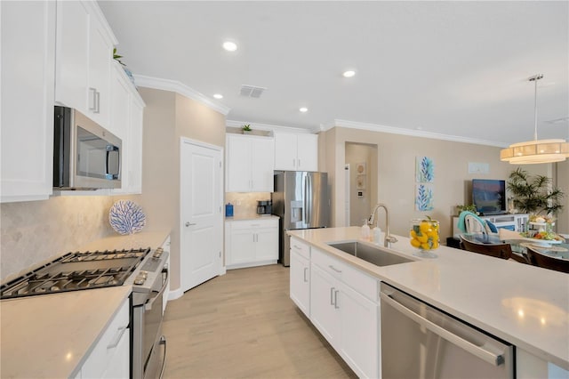 kitchen with stainless steel appliances, white cabinets, hanging light fixtures, and sink