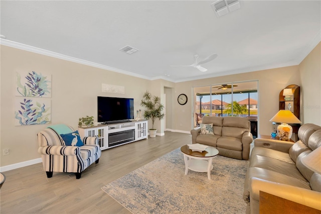 living room with ceiling fan, ornamental molding, and light hardwood / wood-style floors