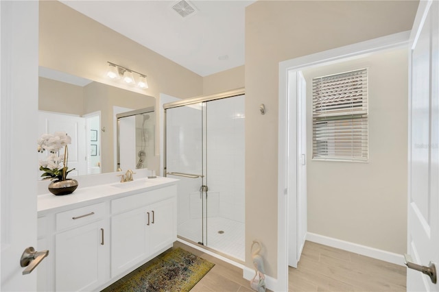 bathroom with a shower with door and vanity