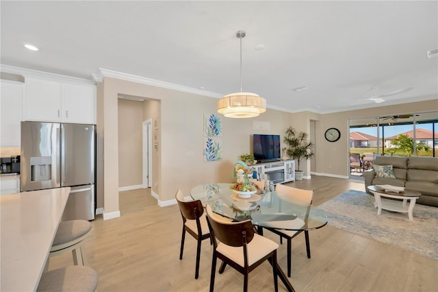 dining room featuring ceiling fan, crown molding, and light wood-type flooring