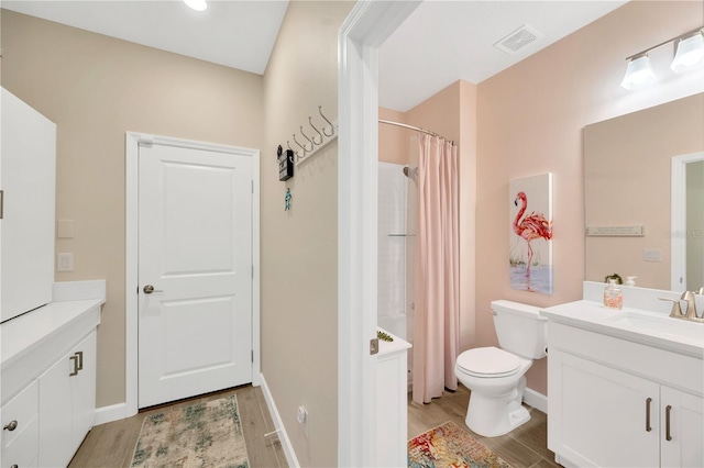 bathroom featuring toilet, a shower with curtain, hardwood / wood-style flooring, and vanity