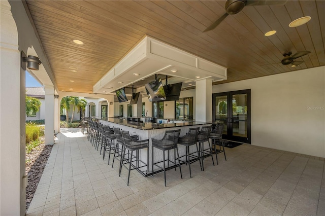 view of patio with ceiling fan and exterior bar