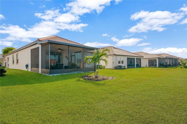 rear view of property with a sunroom and a lawn