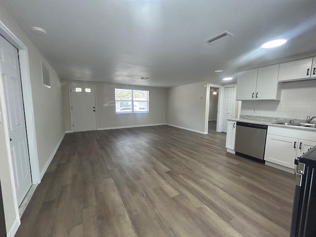 kitchen with stainless steel dishwasher, white cabinets, sink, and tasteful backsplash