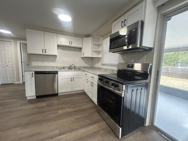 kitchen with dark hardwood / wood-style floors, backsplash, white cabinets, appliances with stainless steel finishes, and sink