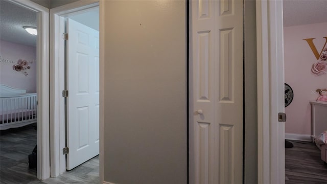 hallway featuring a textured ceiling and hardwood / wood-style flooring