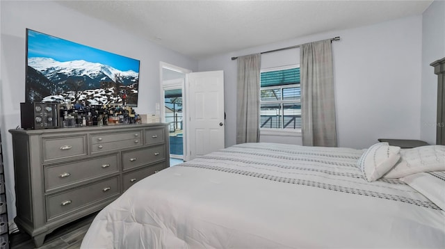 bedroom featuring access to outside and a textured ceiling