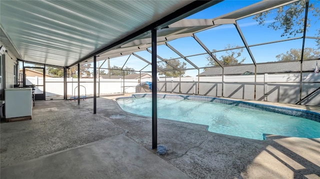 view of pool with a patio area and glass enclosure