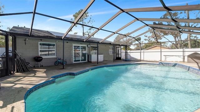 view of swimming pool with a patio and glass enclosure