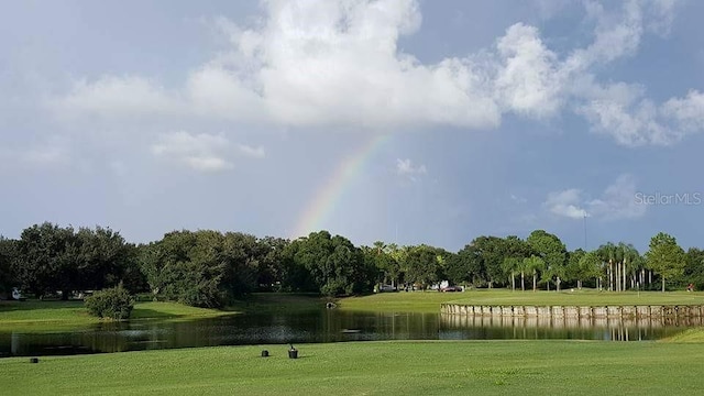 surrounding community with a yard and a water view