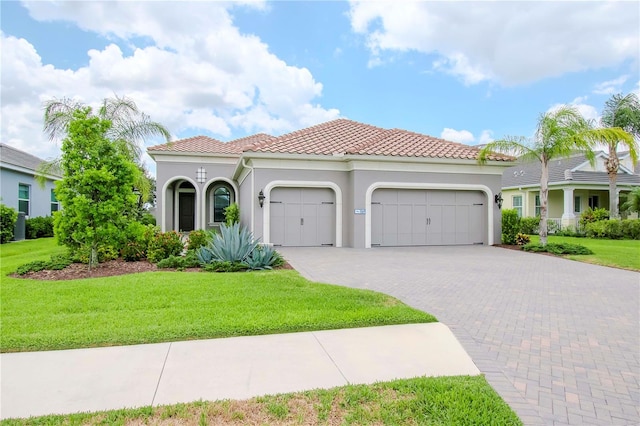 mediterranean / spanish house featuring a garage and a front lawn