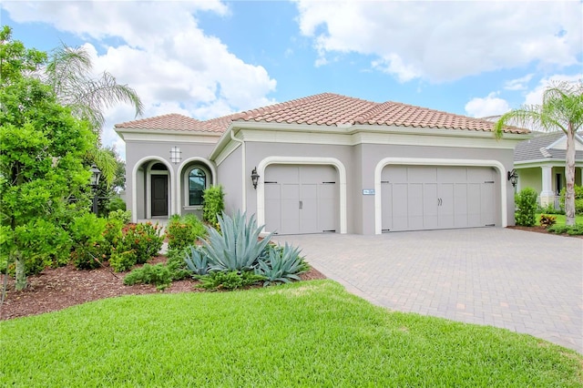 mediterranean / spanish-style home with a front lawn and a garage