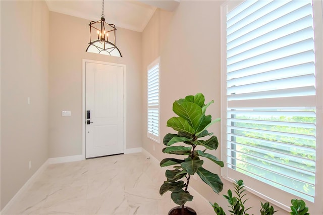 foyer with a chandelier and ornamental molding