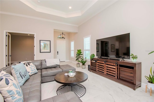 living room featuring a raised ceiling, a chandelier, and ornamental molding