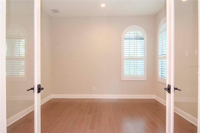 unfurnished room featuring french doors and hardwood / wood-style floors