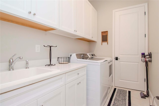 clothes washing area with light tile patterned floors, cabinets, washer and dryer, and sink