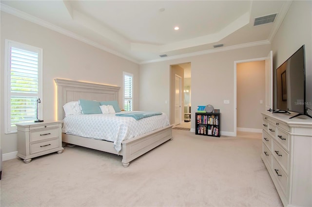 carpeted bedroom with crown molding and a tray ceiling