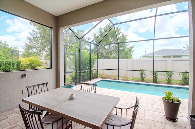 view of pool with glass enclosure and a patio area