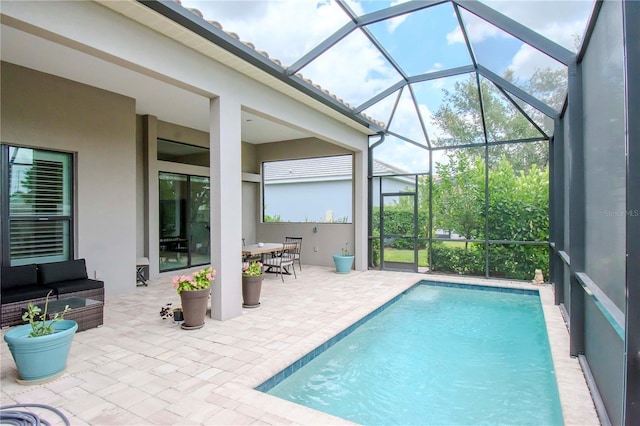 view of pool featuring glass enclosure, an outdoor living space, and a patio