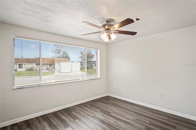 spare room with ceiling fan, dark hardwood / wood-style floors, and a textured ceiling