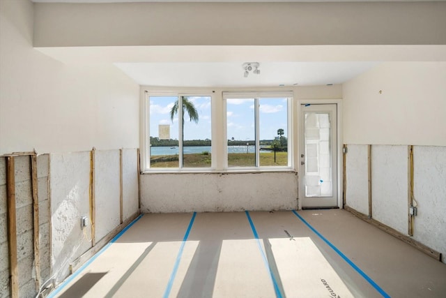 unfurnished room featuring a water view