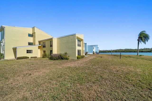 view of home's exterior featuring a lawn and a water view