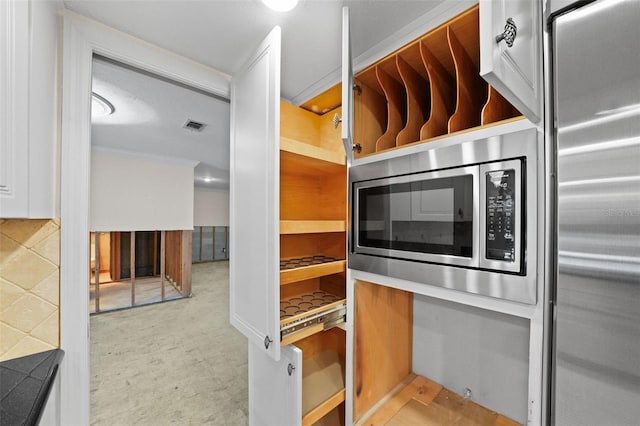 kitchen with white cabinets and stainless steel microwave