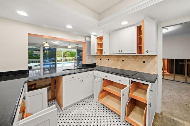 kitchen with sink, white cabinets, a raised ceiling, ornamental molding, and decorative backsplash