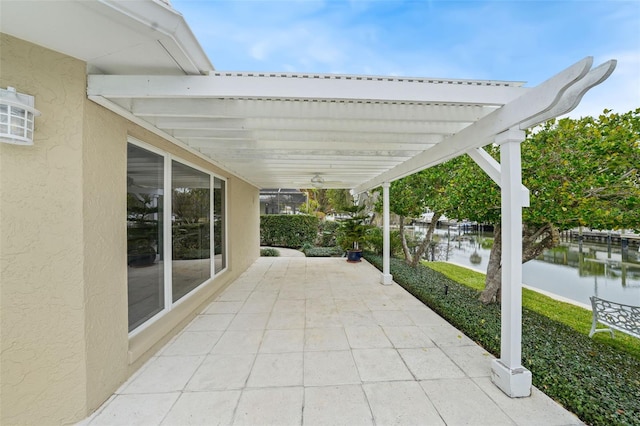 view of patio with a pergola and a water view