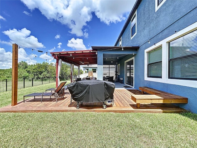 wooden terrace with a lawn and a grill