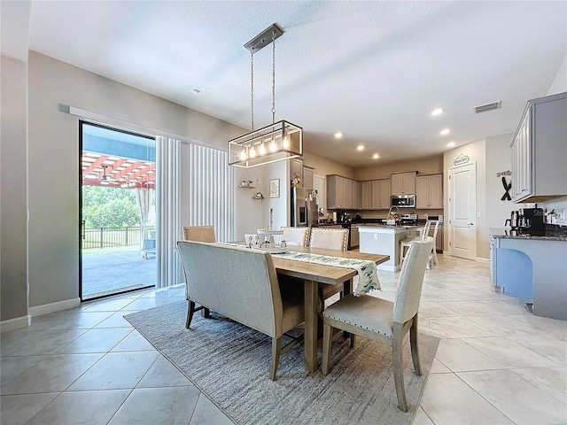 dining area with light tile patterned flooring and a textured ceiling